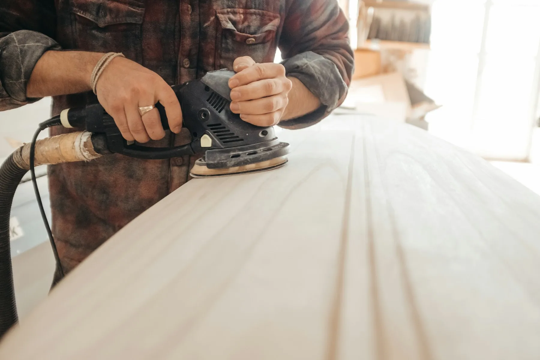 Handwerker schleift eine Holzoberfläche